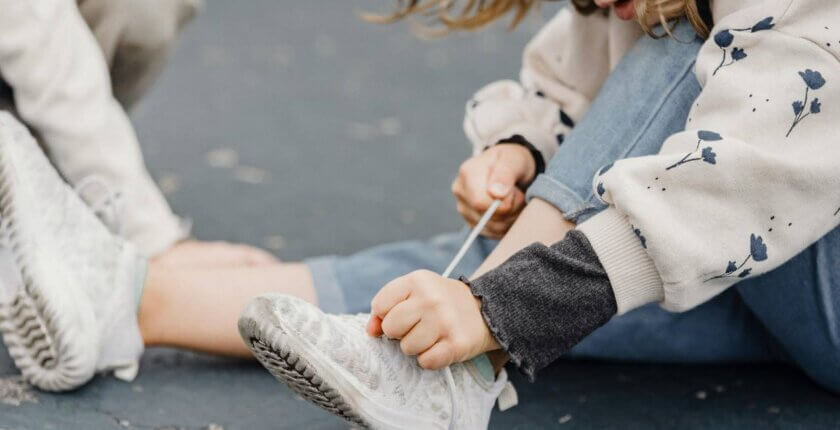 Dete vezuje pertle na patici